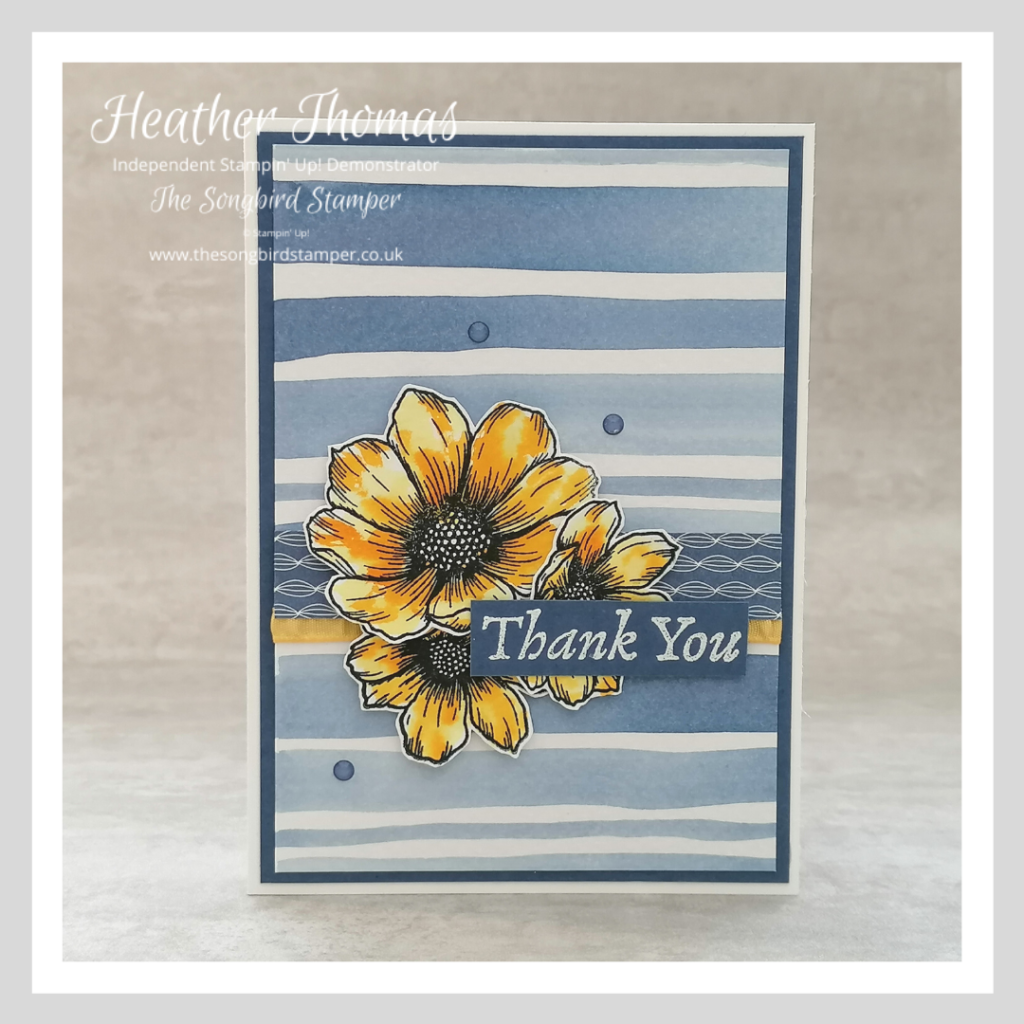 A handmade card with a striped watercolour background