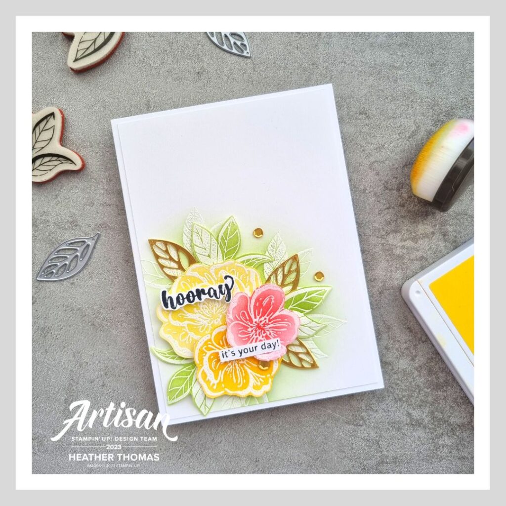 A colourful handmade card with flowers and leaves in reds, oranges, yellow and greens