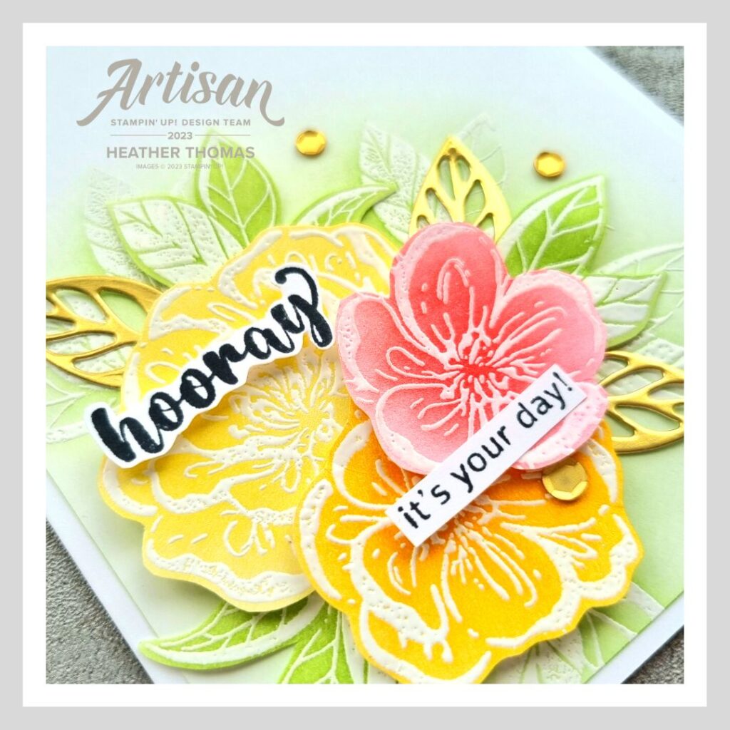 A colourful handmade card with flowers and leaves in reds, oranges, yellow and greens