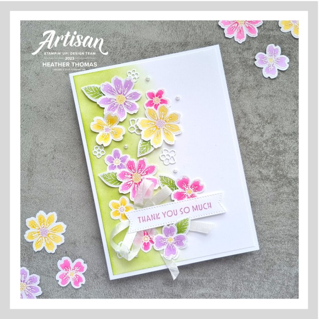 A cute bright coloured handmade card with lots of flowers showing how to use heat embossing and alcohol markers together