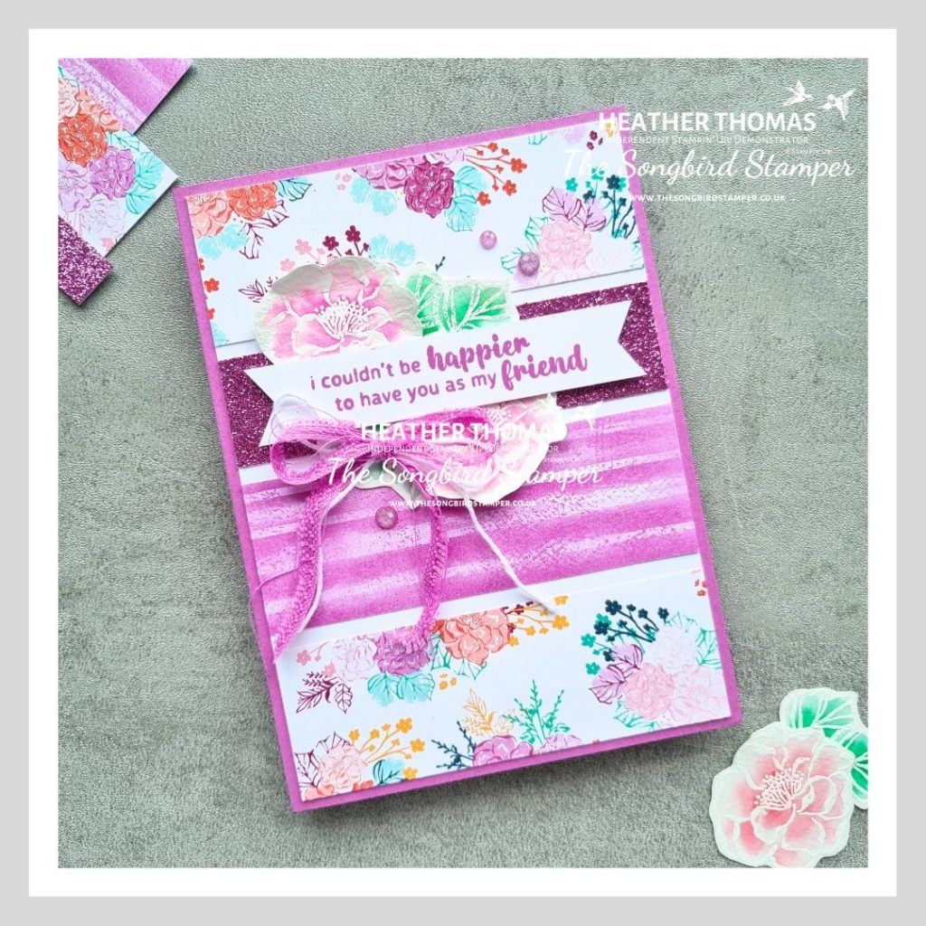 A handmade card based on a card sketch, with purple flowery papers, a purple ribbon bow and a sentiment that says 'I couldn't be happier to have you as my friend'