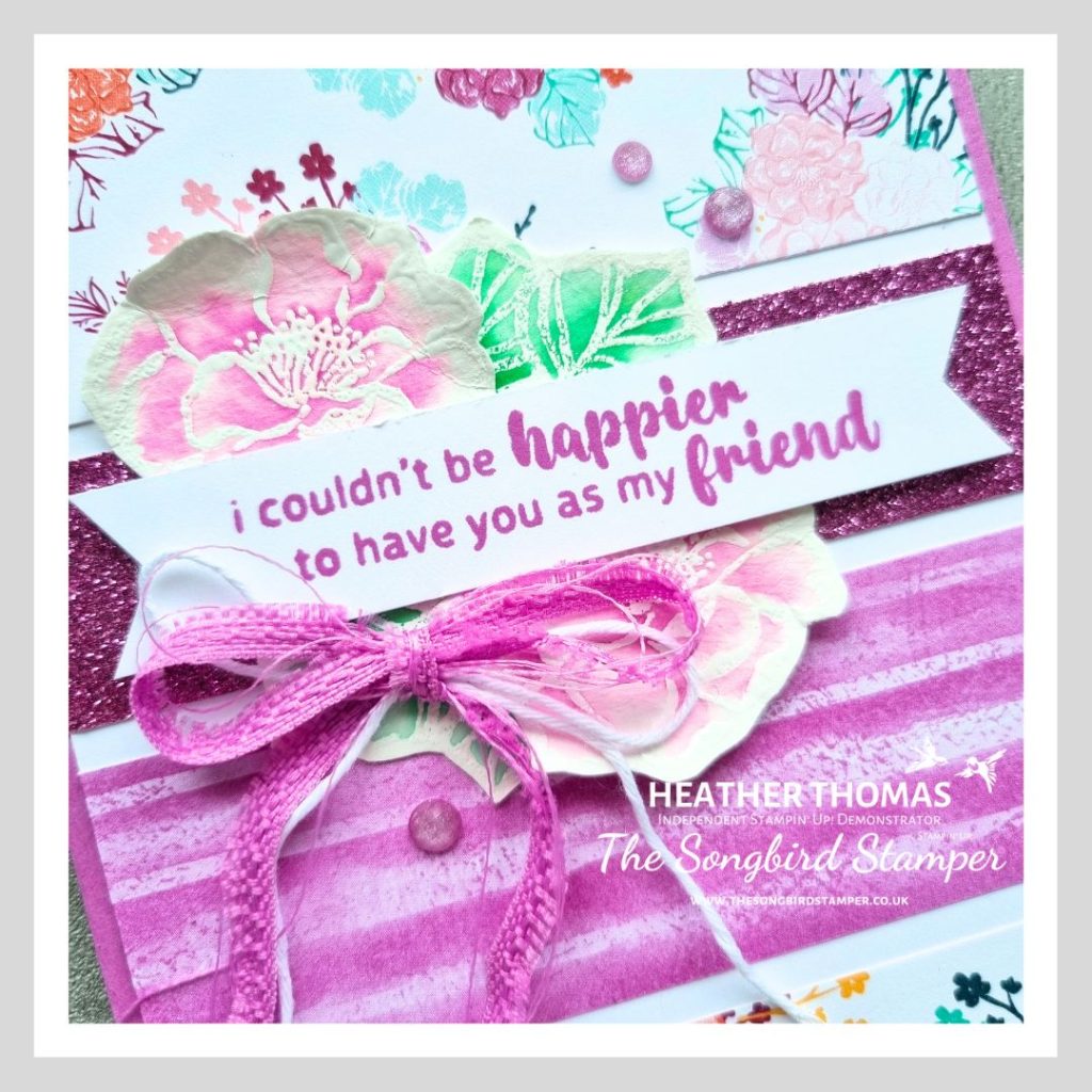 A handmade card based on a card sketch, with purple flowery papers, a purple ribbon bow and a sentiment that says 'I couldn't be happier to have you as my friend'