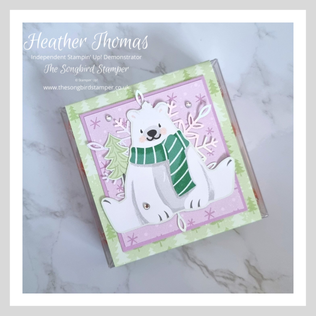 A handmade stocking filler filled with Lindt chocolate balls and decorated with cute polar bear and green and purple papers.