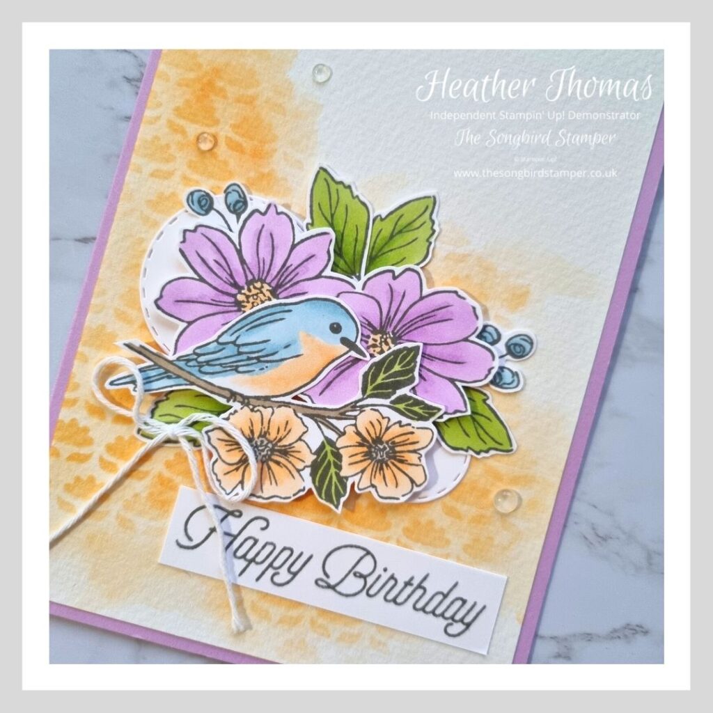A handmade card with birds and flowers showing the difference between stamping with black ink or grey ink