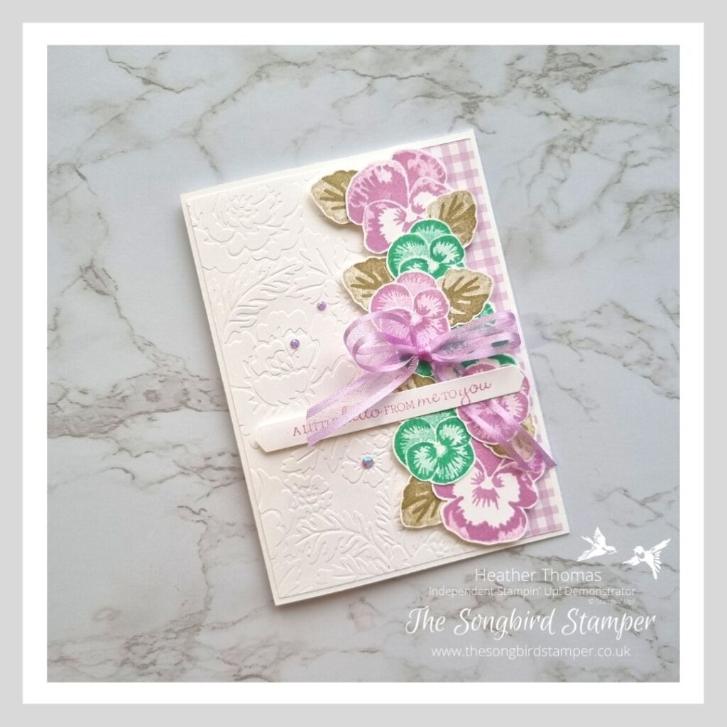 A pretty handmade card using the subtle embossing folder trick with flowers in purple and teal.