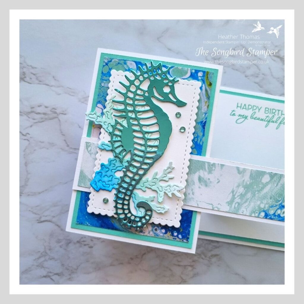 A close up of a masculine z-fold card in blues and greens with a gorgeous seahorse on the front. 