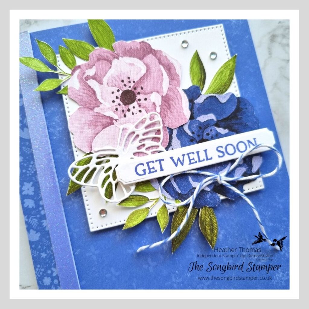 A handmade get well soon card with flowers and a butterfly in purple and blue