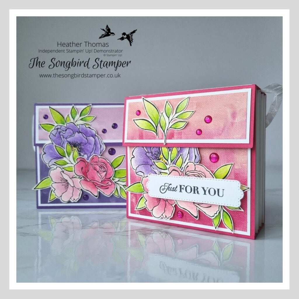 Two accordion style gift bags in pink and purple, decorated with flowers and leaves