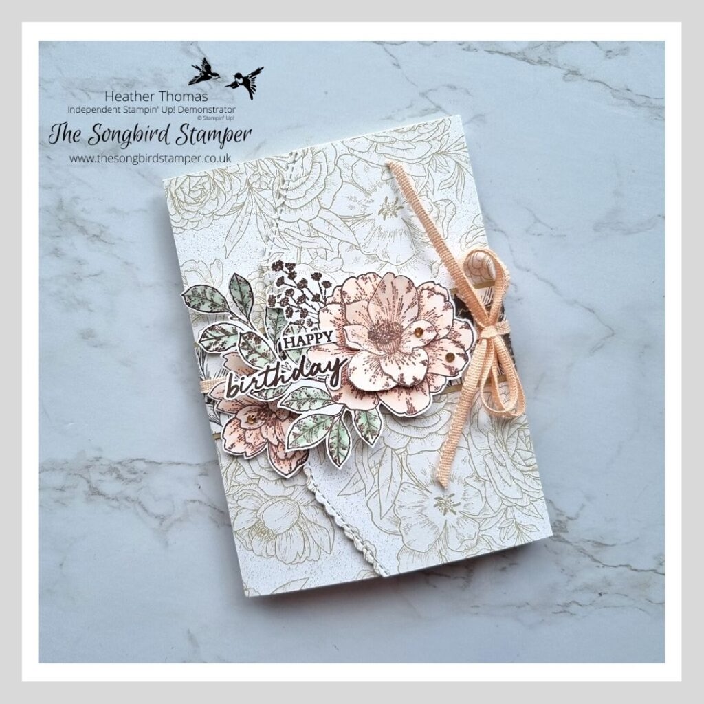 The outside of one of my handmade wedding invitations in cream, mint and pink with flowers and a bow