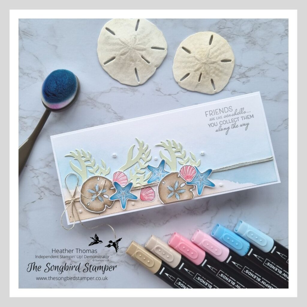 A handmade card showing how to create a beach scene, decorated with seashells and pearls
