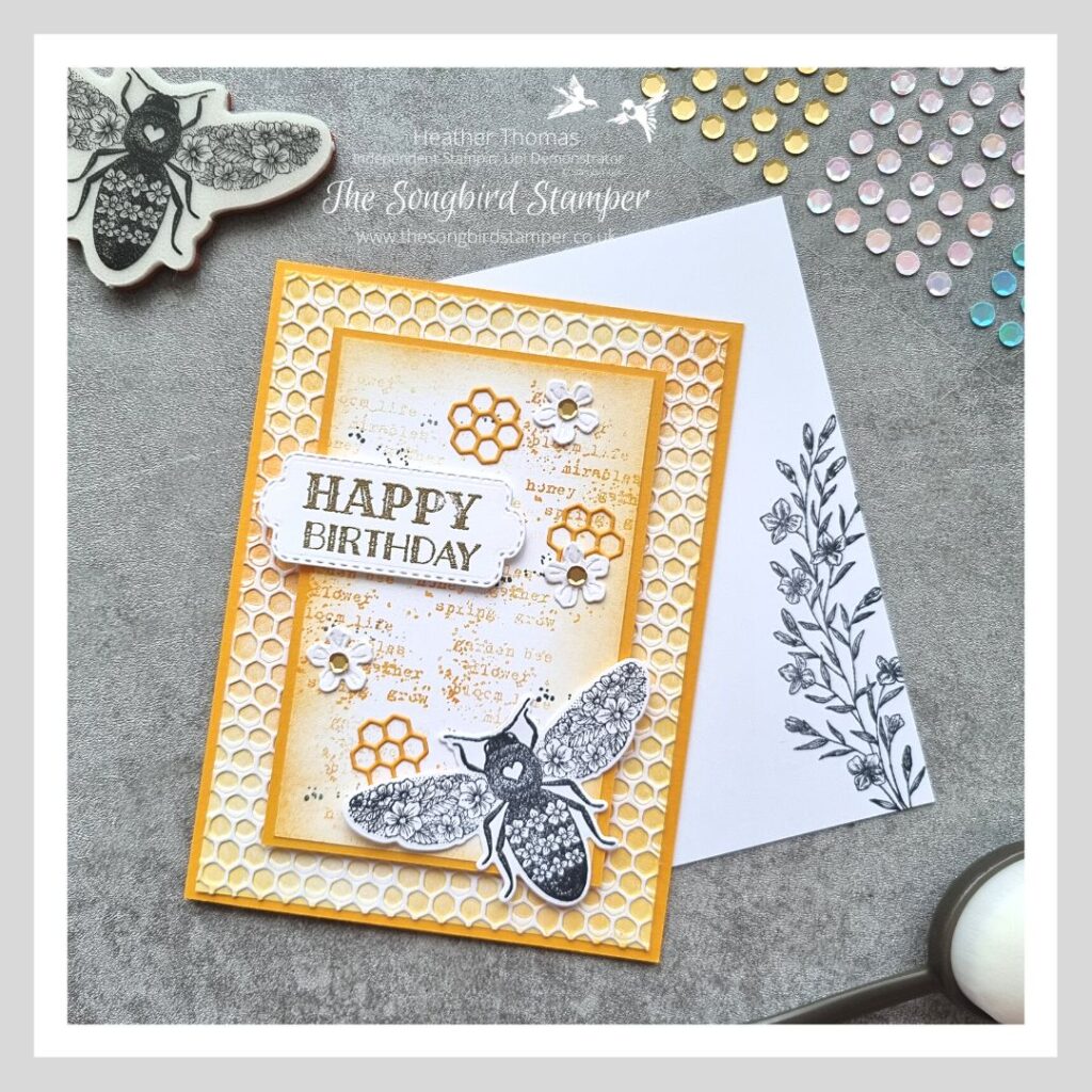 A handmade card in yellows and oranges, with a bee on the front and using the inky embossing folder technique