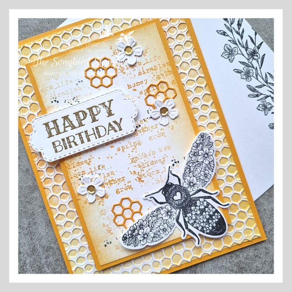A handmade card in yellows and oranges, with a bee on the front and using the inky embossing folder technique