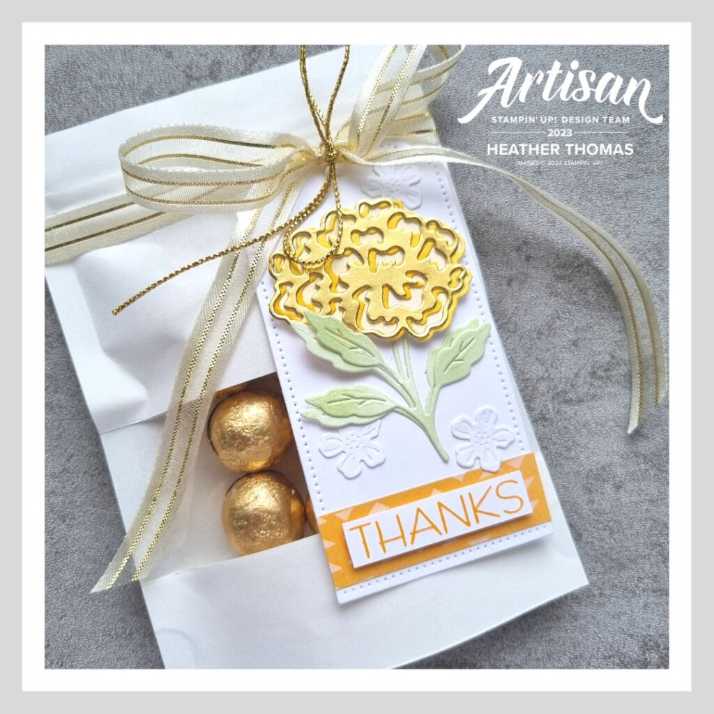 A handmade treat packaging in yellow and orange, with flowers from the Marigold Moments bundle