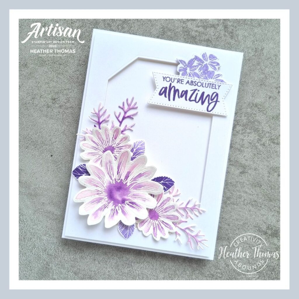 A handmade card in purple with watercoloured flowers and the words 'You're absolutely amazing'