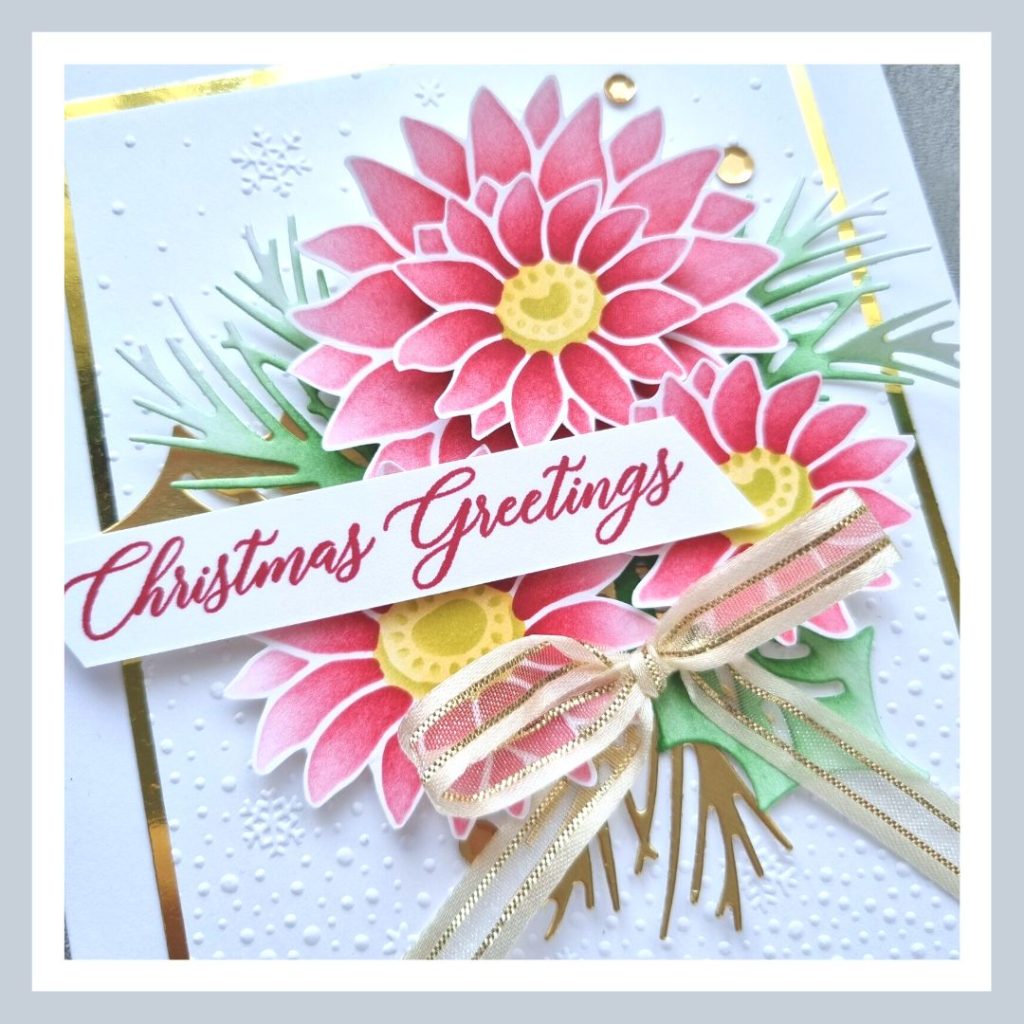 A handmade Abundant Beauty Christmas Card in reds, greens and golds, with Poinsettia like flowers on an embossed white background.
