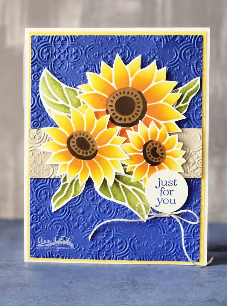 A handmade card using the Abundant Beauty Decorative Masks from stampin' Up! with yellow sunflowers on a blue embossed background.