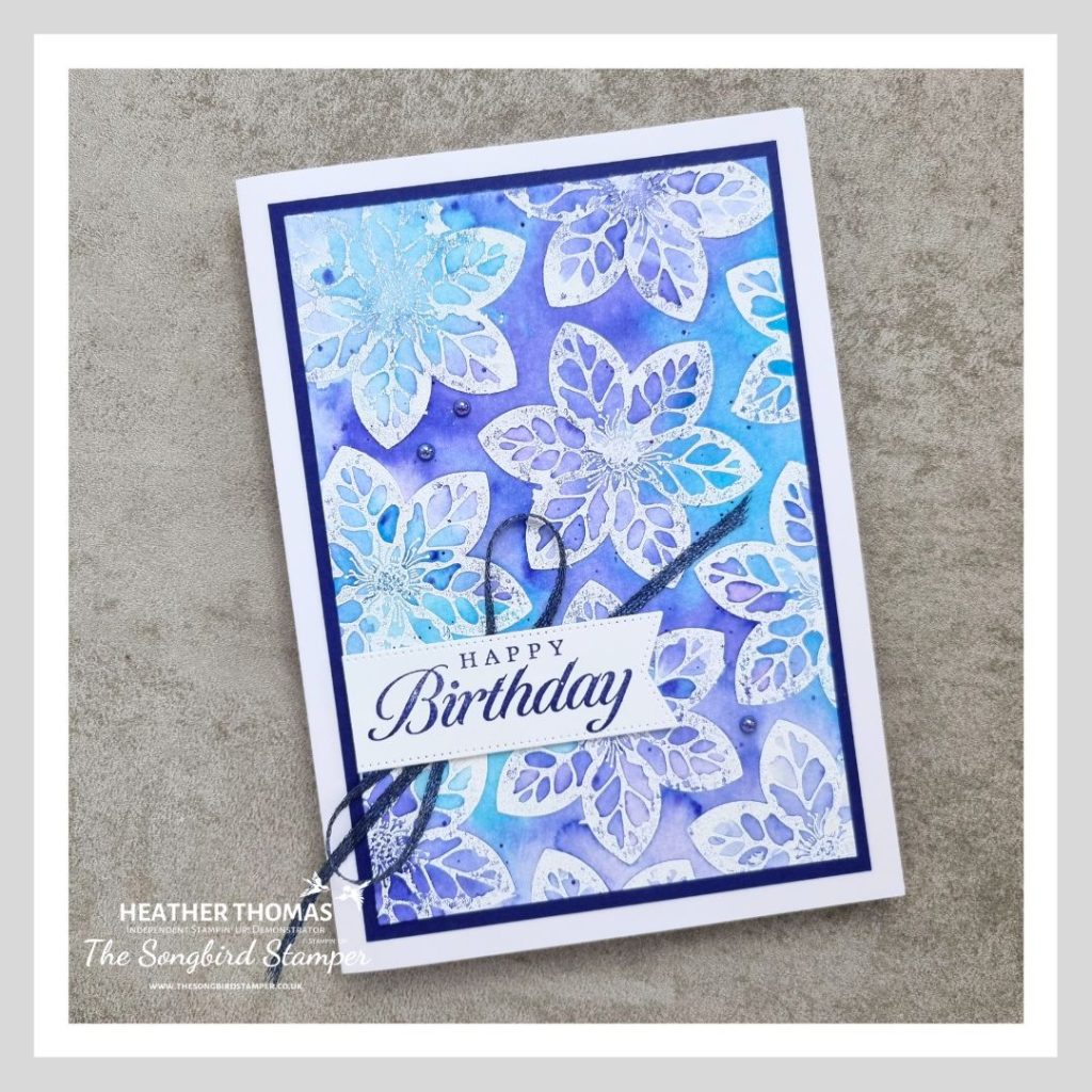 A handmade card using the emboss resist technique and watercolour, in blues and purples.