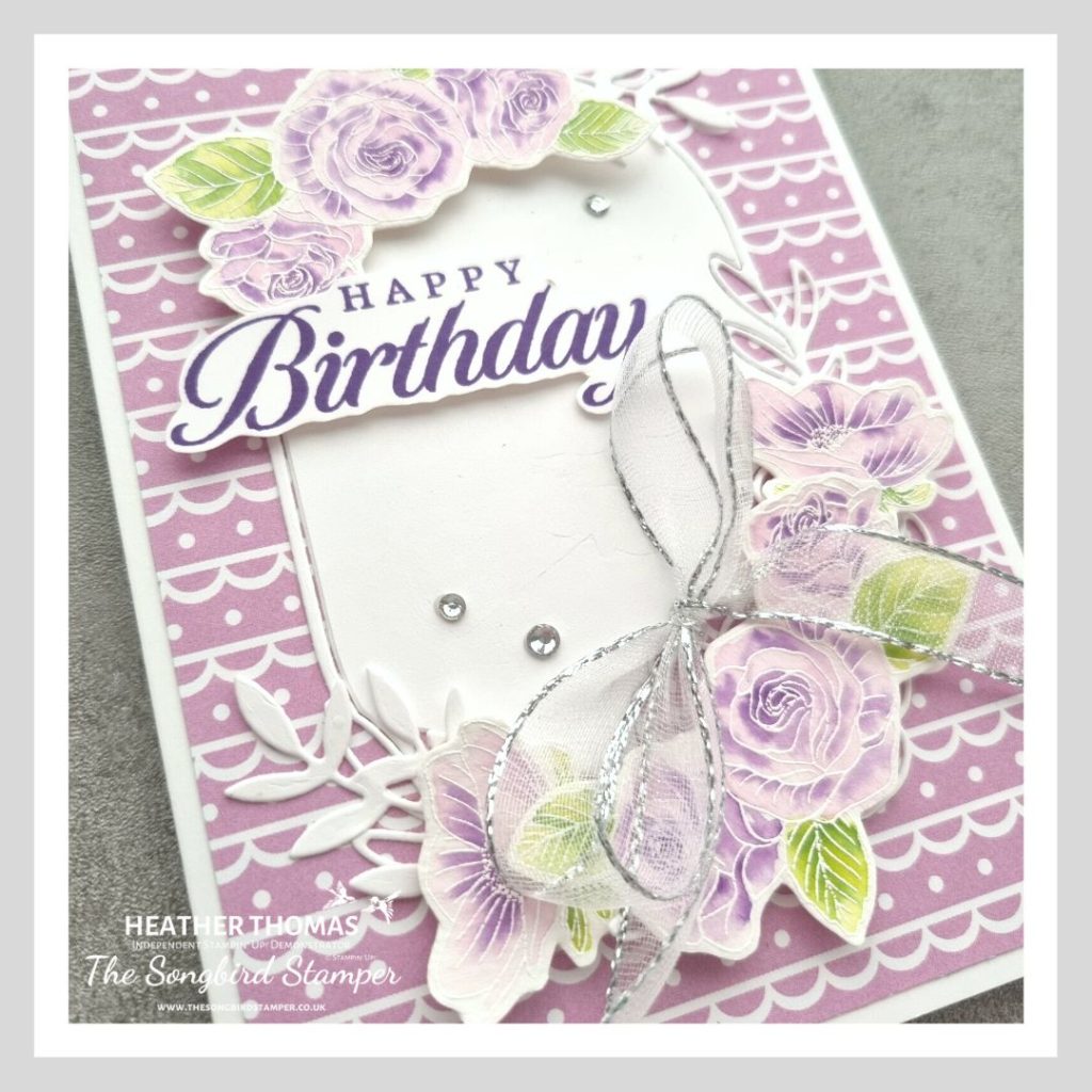 A handmade card in purple with flowers and a happy birthday sentiment, using the watercolour emboss resist technique