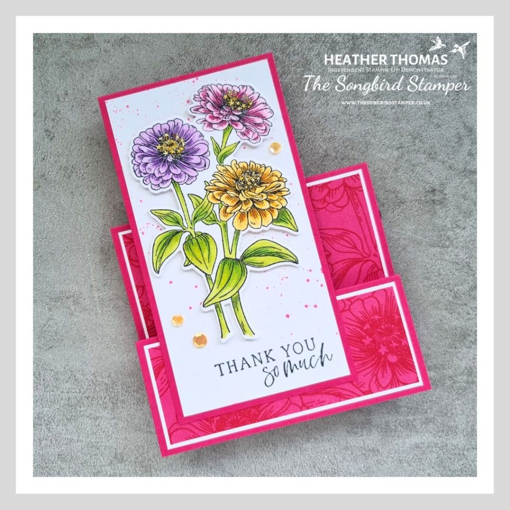 A faux stepper card in pink, with flowering zinnias coloured in with green, yellow, purple and pink